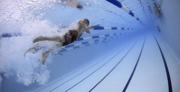 Un hombre nada en una piscina