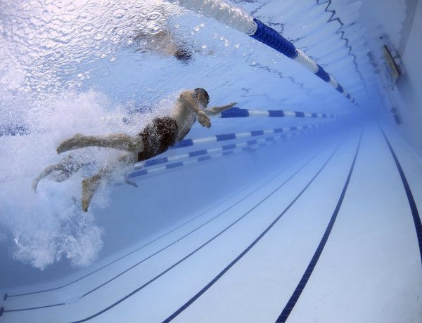 Un hombre nada en una piscina