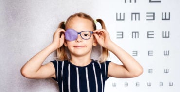 niña con gafas y parche en el ojo